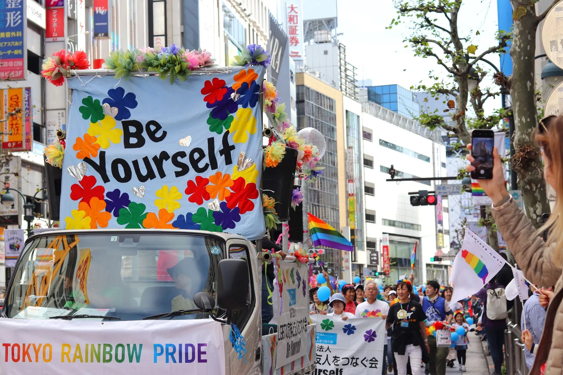 משאית מקושטת בפרחים צבעוניים ושלט Be Yourself במצעד טוקיו ריינבו פרייד בשיבויה